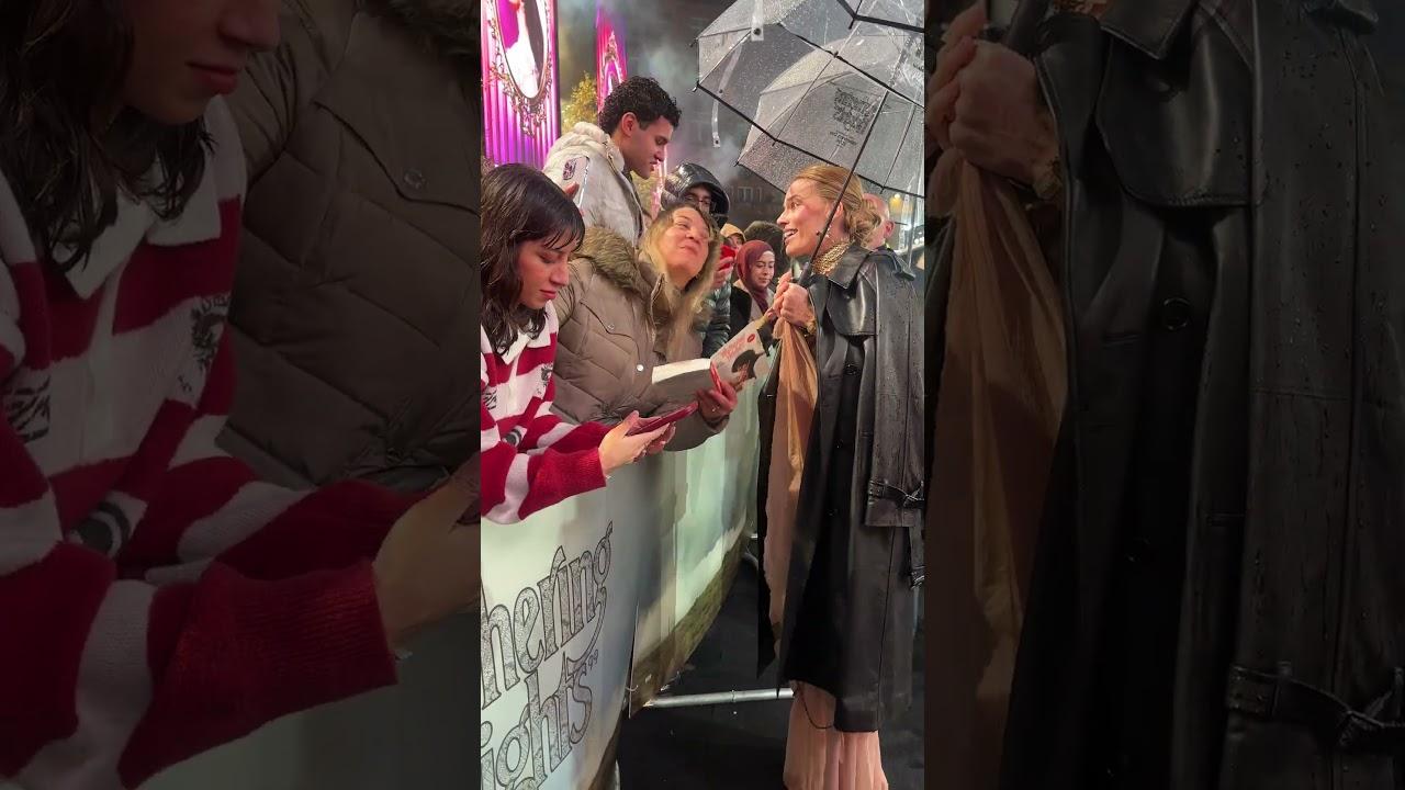 Signing in the rain... Margot Robbie meets fans at the "Wuthering Heights" UK Premiere
